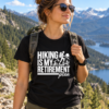 hiking-is-my-retirement-plan-funny-hiking-shirt Black hiking shirt with Hiking Is My Retirement Plan text and mountain hiker graphic